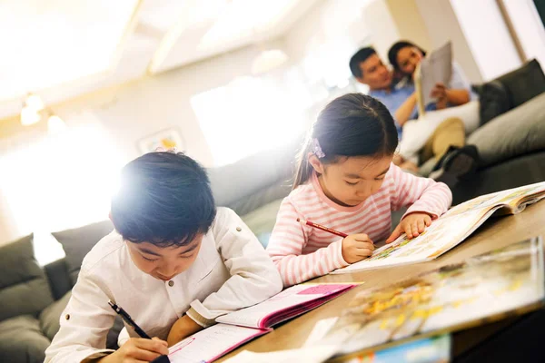 Adorables Niños Chinos Haciendo Deberes Casa Padres Sentados Detrás —  Fotos de Stock