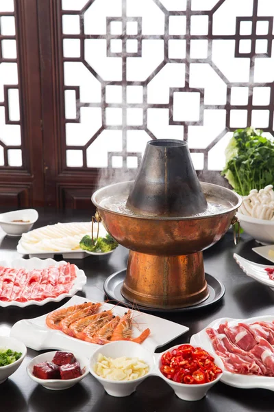 テーブルの上に肉 野菜を入れた銅鍋とプレート 料理コンセプト — ストック写真