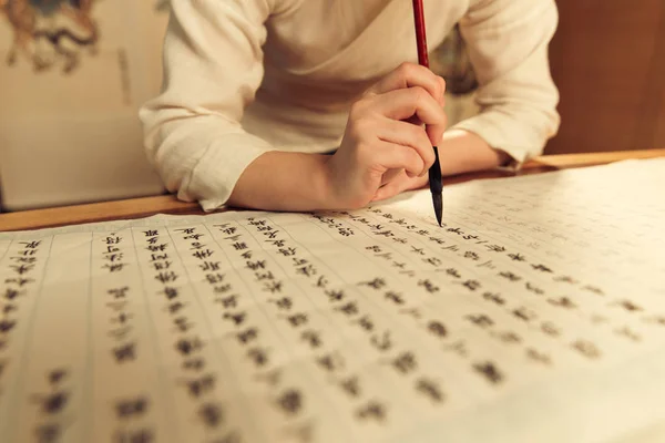 書道ブラシを保持し 漢字を書く女性の切り取られたショット — ストック写真