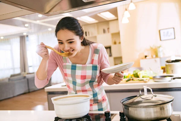 Счастливая Молодая Азиатская Женщина Фартуке Дегустирует Вкусное Блюдо Время Приготовления — стоковое фото