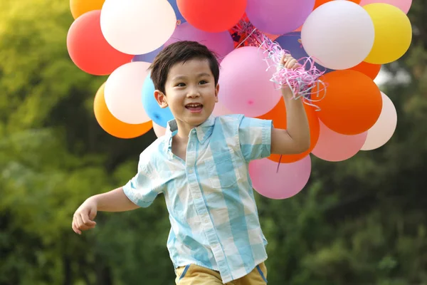 Boy holding bunch of balloons — Stock Photo, Image