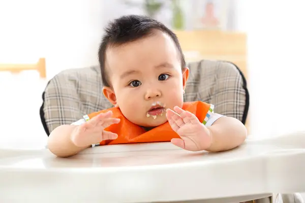 可愛いですアジアの赤ちゃん男の子座って高い椅子と見ますカメラ — ストック写真