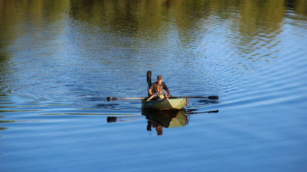 Menschen in einem Holzboot auf den Rudern überqueren den Fluss — Stockfoto