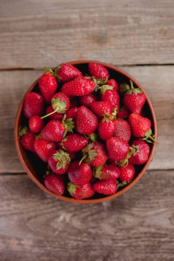 Ahşap bir masa üzerinde bir kase çilek