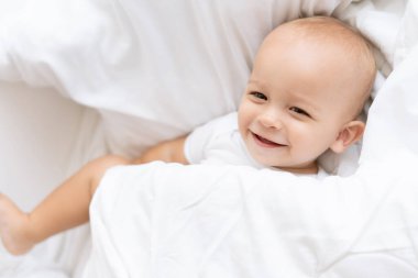 Mutlu erkek bebek battaniyenin altında