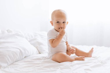 Küçük çocuk beyaz bir yatakta uyandı.