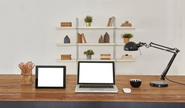 dizüstü ve tablet ahşap masa ve ofis iç. Kitaplık arka plan ile ev Aksesuar kitaplar ve tesisleri