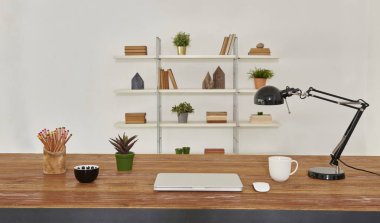 dizüstü ve tablet ahşap masa ve ofis iç. Kitaplık arka plan ev Aksesuar kitap, kahve ve bitkiler