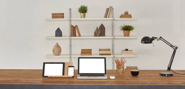 dizüstü ve tablet ahşap masa ve ofis iç. Kitaplık arka plan ile ev Aksesuar kitaplar ve tesisleri