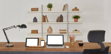 dizüstü ve tablet ahşap masa ve ofis iç. Kitaplık arka plan ile ev Aksesuar kitaplar ve tesisleri