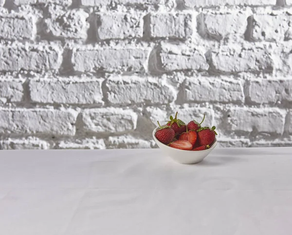 strawberries behind brick wall white background