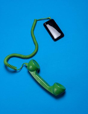 cep telefonu ve yeşil cep telefonu mavi arkaplanın arkasında