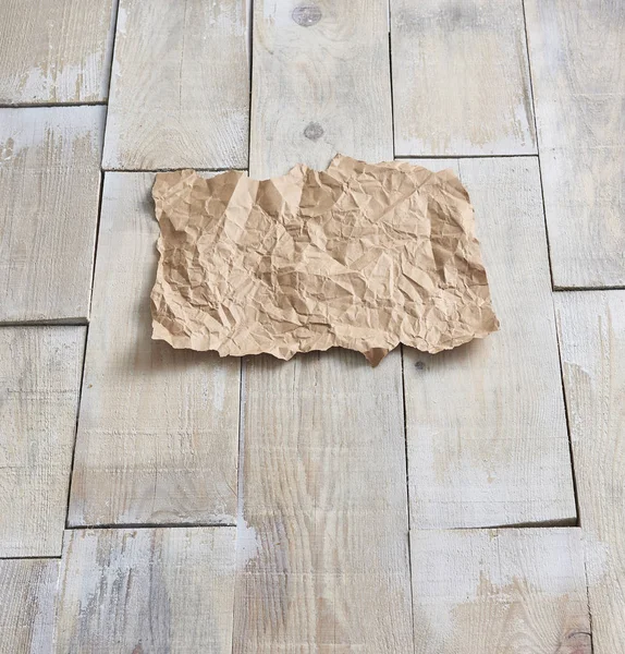 在背景的木地板上 皱褶的纸 — 图库照片