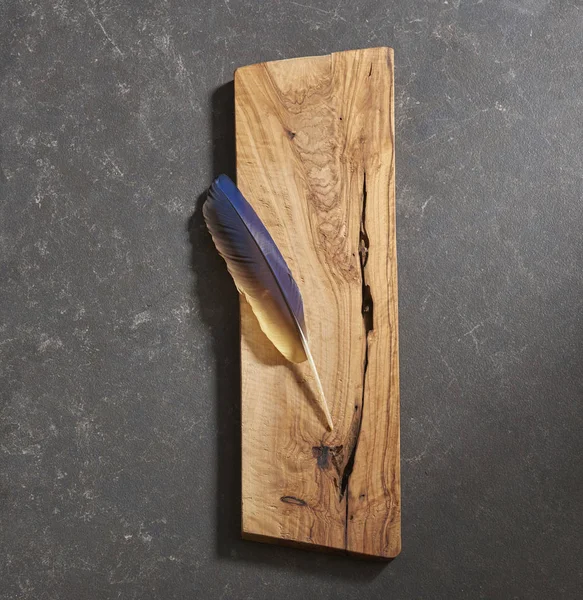 black background cutting board with feather
