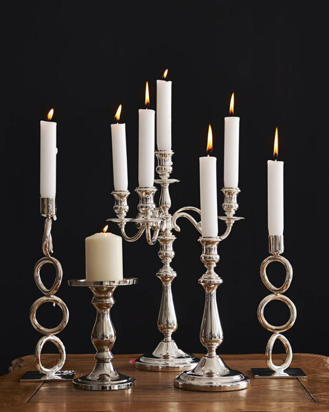 black wall with silver candlestick and white candles