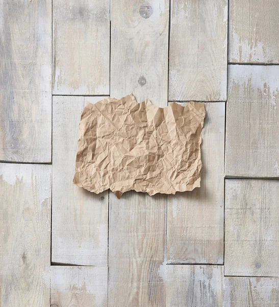 在背景的木地板上 皱褶的纸 — 图库照片