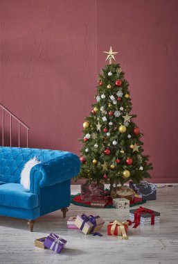 Kırmızı bordo Noel Duvarı Noel odası kırmızı kavram mavi ve gri kanepe dekorasyonu çalışma masası Noel ağacı, saat ve lamba.