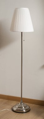 Oda duvarındaki lamba arka planda beyaz ve metal ayrıntı.