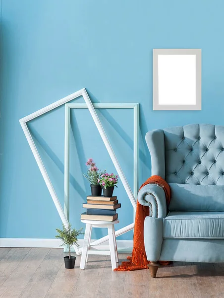 Decorative armchair, blue wall and frame concept with wooden chair, book vase of plant style.