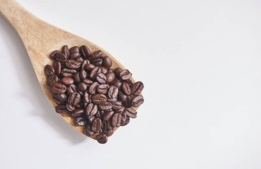 Kahve çekirdekleri ile tahta kaşık ve yakın beyaz arka plan üzerinde yukarı ve izole. 