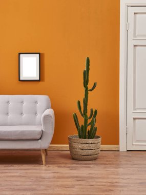 Turuncu duvar ve gri kanepe, bitki ile iç oda. 