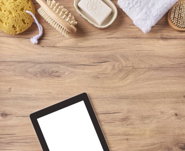  nesne ile banyo salonu, fırça, havlu, masada sabun ve tablet pc.