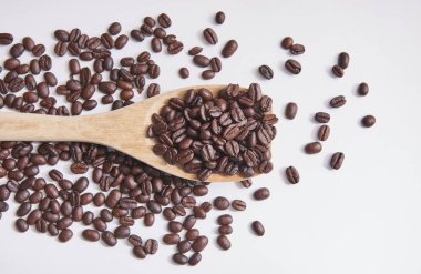 Kahve çekirdekleri ile tahta kaşık ve yakın beyaz arka plan üzerinde yukarı ve izole. 