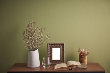 Dekoratif masa ve tablo stili ve vazo bitki çerçeve cam su ve Resepsiyon iç oda yeşil duvar arka plan ile ilgili kitap
