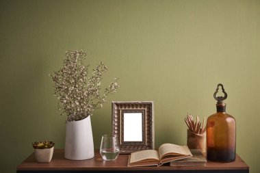 Dekoratif masa ve tablo stili ve vazo bitki çerçeve cam su ve Resepsiyon iç oda yeşil duvar arka plan ile ilgili kitap