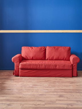 koyu mavi arka plan ve kırmızı kanepe . Kahverengi parke tarzı. 