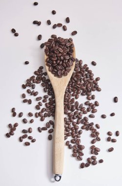 Kahve çekirdekleri ile tahta kaşık ve yakın beyaz arka plan üzerinde yukarı ve izole. 