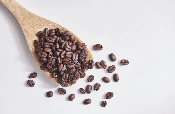 Kaffebönor Med Träsked Och Stäng Upp Vit Bakgrund Och Isolerade — Stockfoto