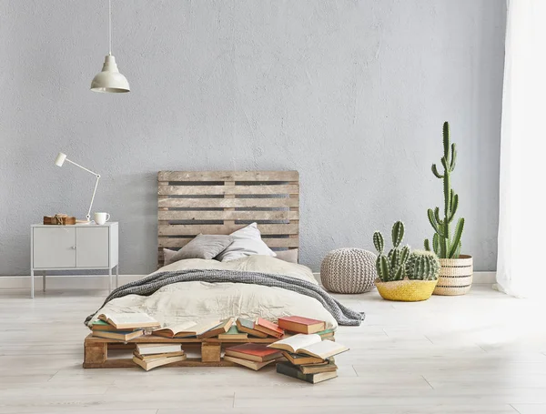 Bed room is in the grey stone wall with wooden pallet style ,cactuses in bed room