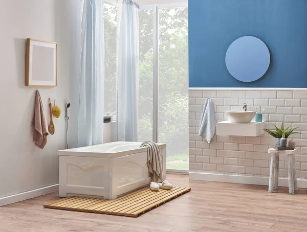 White and blue wall ,decoration white ceramic and sink style in the bath room. Tub is in front of the door in the bath room style.