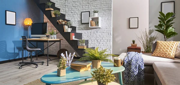 Modern living room, white brick wall, wooden desk and desktop , black stair, carpet sofa in  interior.