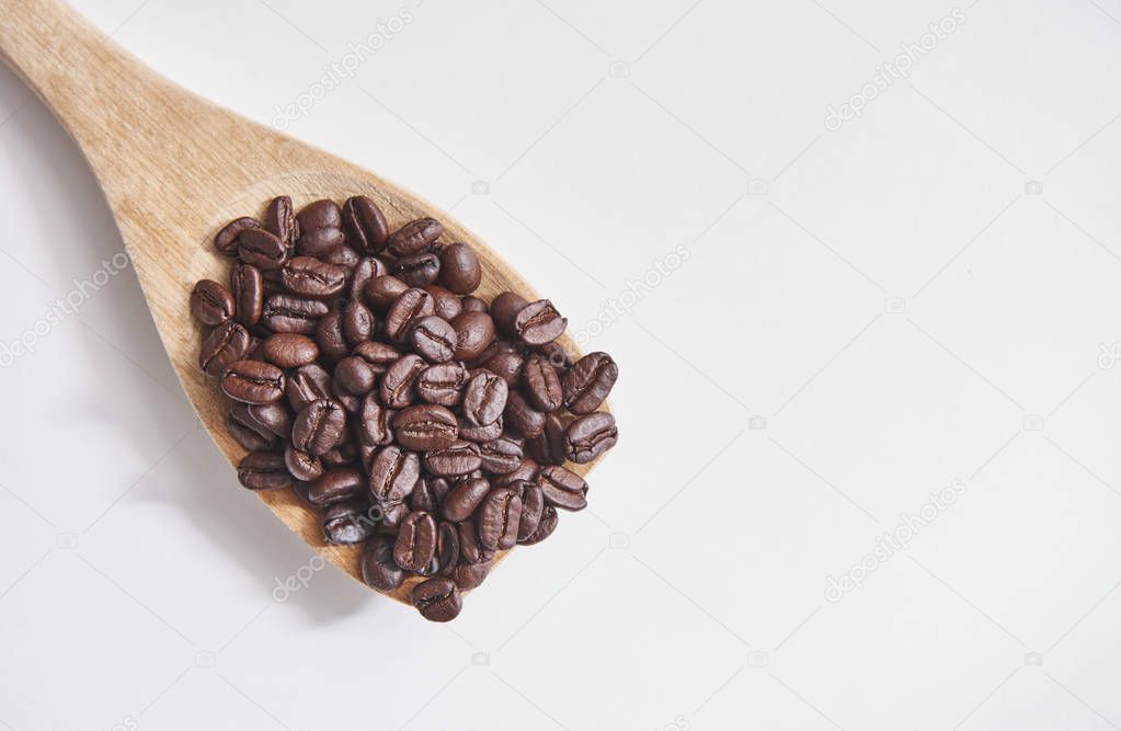 Coffee beans with wooden spoon and close up on white background and isolated. 
