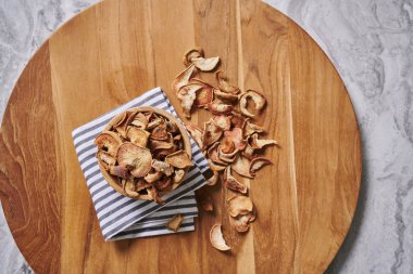 Peçete ve gri mermer arka plan ile ahşap kesme tahtası üzerinde kuru elma