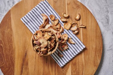 Peçete ve gri mermer arka plan ile ahşap kesme tahtası üzerinde kuru elma