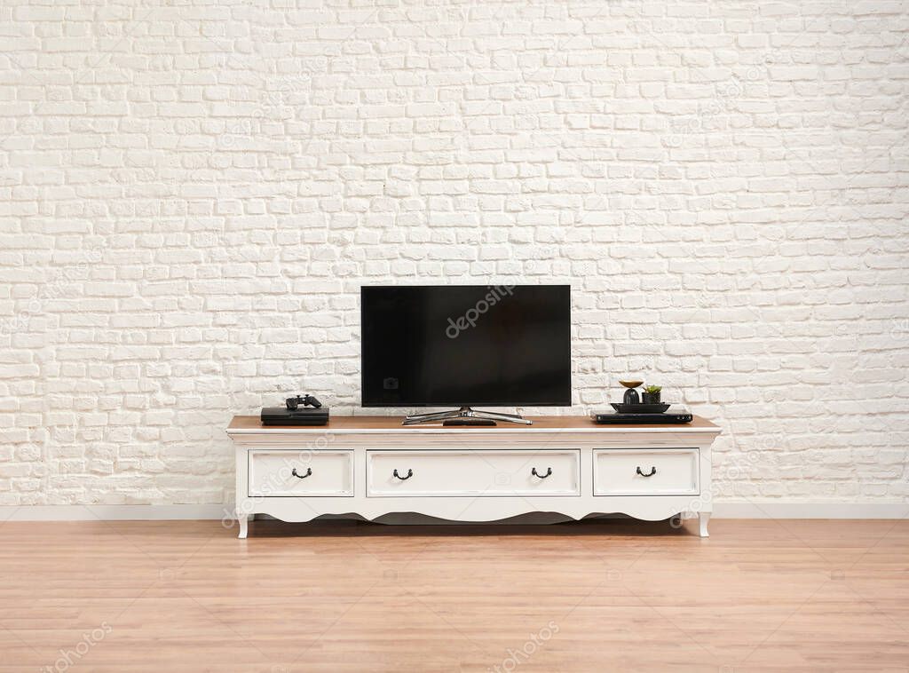 Decorative white classic television unit and brick wall background.