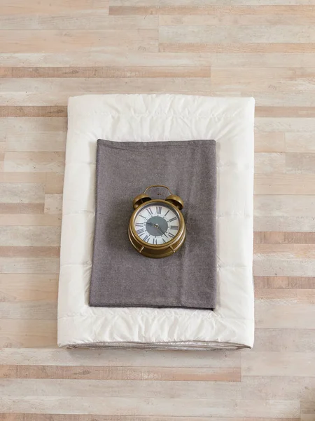 White quilt and pillow, book, cotton and clock object, comfortable decor.