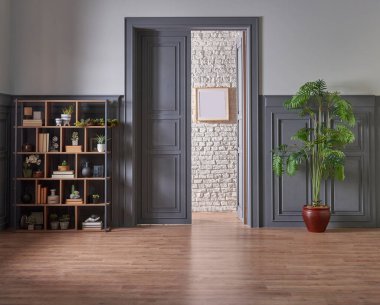 Klasik gri duvar ve kapı tarzında dekoratif ahşap kitaplık, yeşil bitkinin lamba çerçevesi ve vazosu.