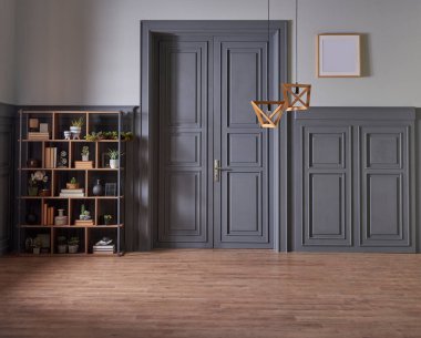 Klasik gri duvar ve kapı tarzında dekoratif ahşap kitaplık, yeşil bitkinin lamba çerçevesi ve vazosu.