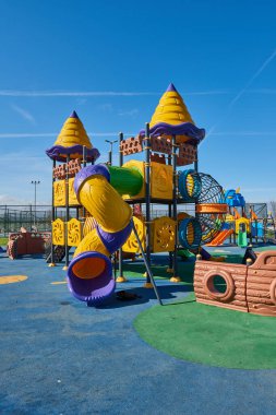 Sarı ve mavi slaytlar modern yeni tarz parkında sallanıyor..