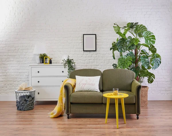 Classic green sofa and yellow coffee table, white cabinet in the room and plant style.