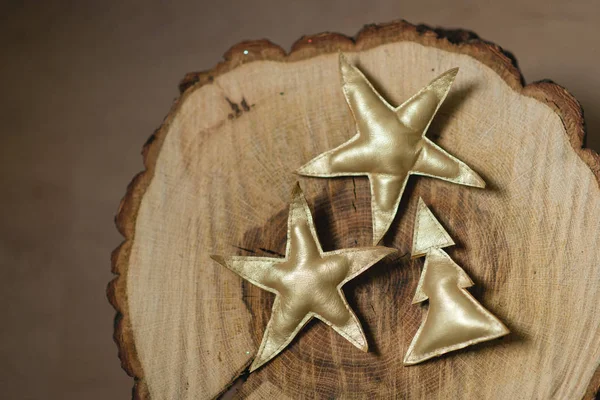 Altın yıldızlar ve ahşap arka plan üzerinde bir Noel ağacı süsle