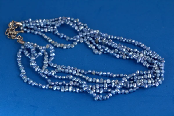 Strings of blue freshwater pearls on a blue background