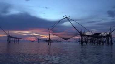 Pakpra, Tayland Phattalung, gündoğumu gökyüzü arka plan ile küçük balık yakalamak için büyük kare dip ağlar silüeti.