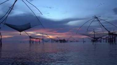 Pakpra, Tayland Phattalung, gündoğumu gökyüzü arka plan ile küçük balık yakalamak için büyük kare dip ağlar silüeti.