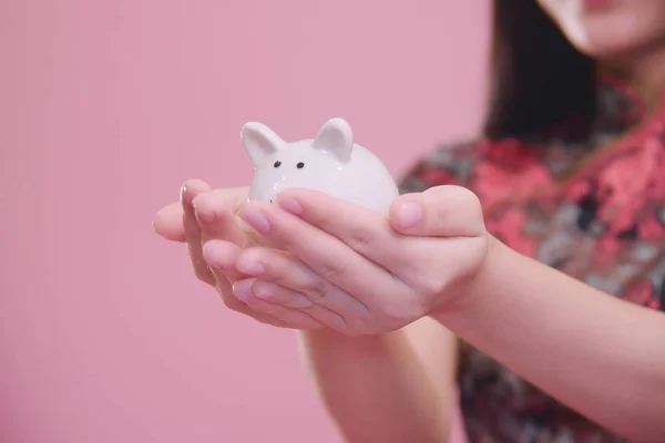 若い女性の小さな貯金に手ピンク Blackground お金の節約のコンセプト — ストック写真
