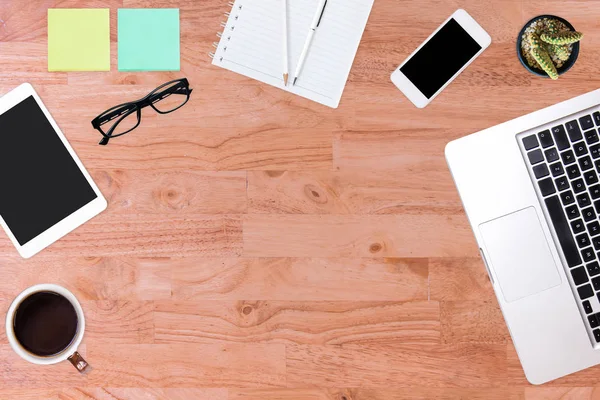 Modern office desk wooden table with laptop computer, smartphone, notebook, pen, pencil, and cup of coffee. Working desk table concept.Top view with copy space, flat lay.